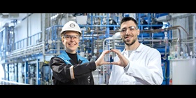 Two Covestro employees form a circle with their hands.
