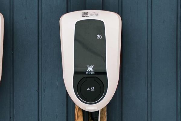 Three EV-Charging stations in a row mounted to a wooden outside wall