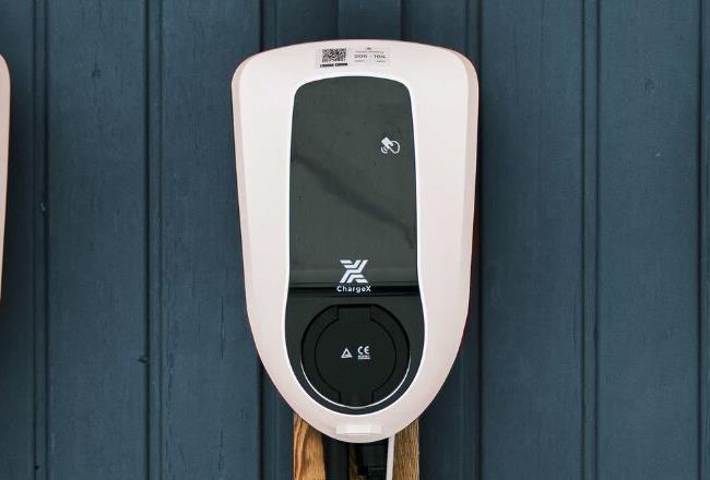 Three EV-Charging stations in a row mounted to a wooden outside wall