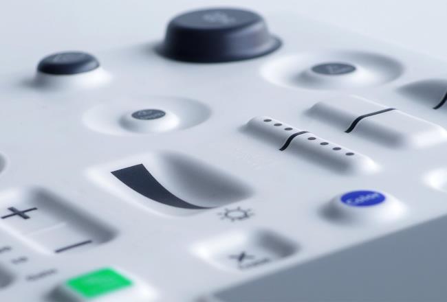 Molded plastic control panel with a variety of in-mold electronic controls including buttons and sliders.