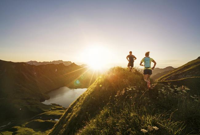 Two runners on hill at sunset