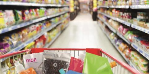 Aisle with shopping cart holding a range of unlabelled consumer goods with flexible TPU packaging