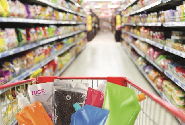Aisle with shopping cart holding a range of unlabelled consumer goods with flexible TPU packaging