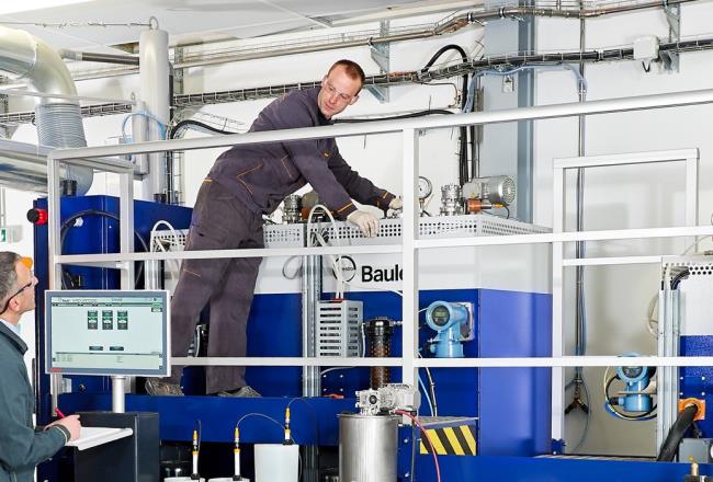 Men handling a large machine used in the flooring coating production.