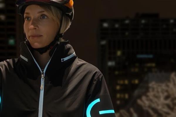 A cyclist wearing an EL cycling jacket in the nighttime