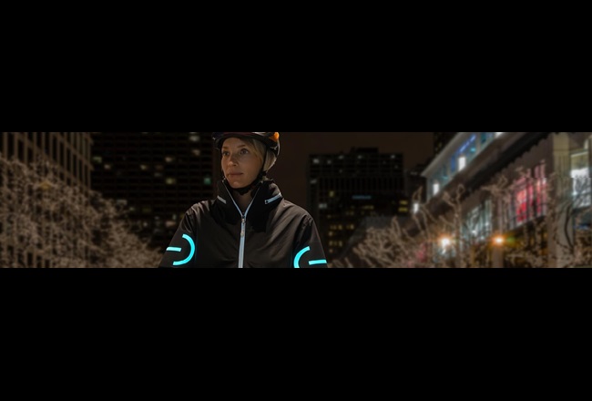 A cyclist wearing an EL cycling jacket in the nighttime