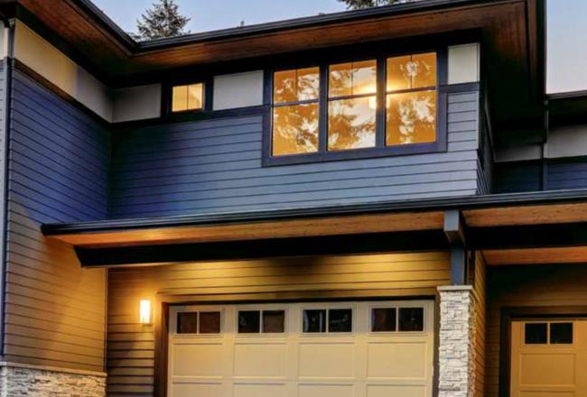 Modern residential home with blue siding and navy window frames