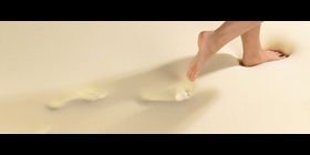 A woman walking on viscoelastic foam that sinks in underneath her footsteps.