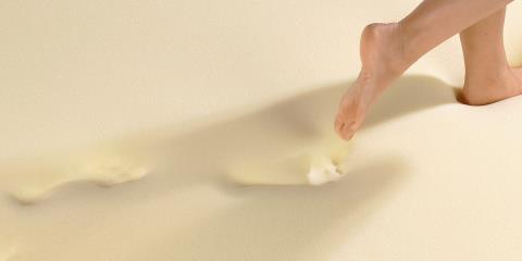 A woman walking on viscoelastic foam that sinks in underneath her footsteps.
