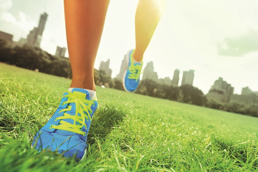 Feet in sport shoes on grass field