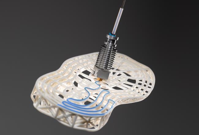 Printing head applicating adhesive on a shoe sole.