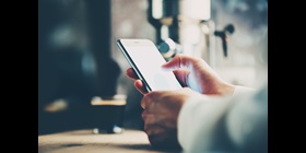 Ein Mann hält ein Smartphone in den Händen, um Textnachrichten zu lesen.