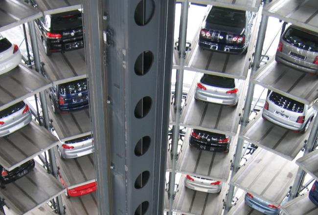 Many cars parked in large parking garage.