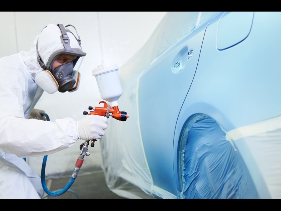 在车身上喷涂中涂的男子