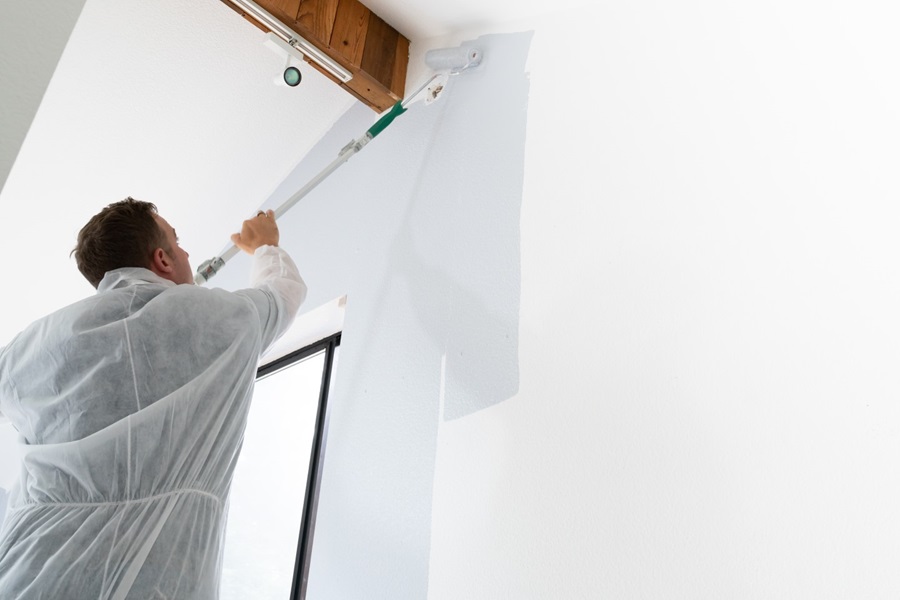 Man painting interior with gray paint