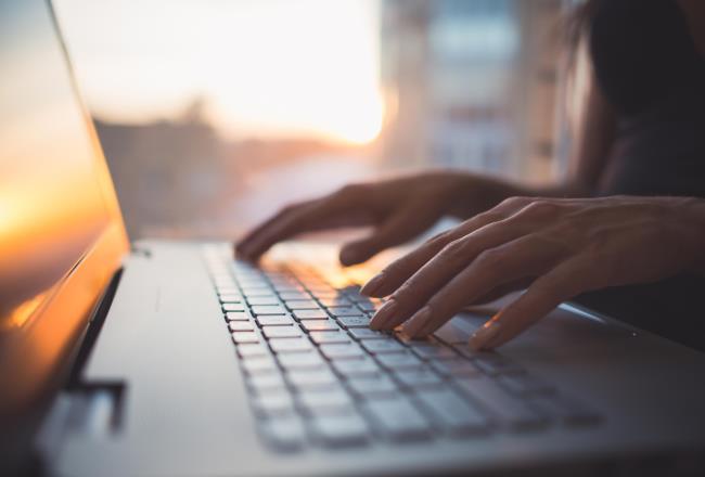 Woman works at the computer, taps on the keyboard.