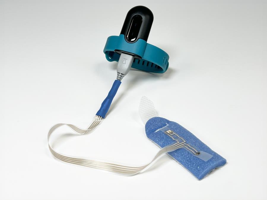Demonstrator medical wearable with electronics controller and fingertip SpO2 sensor.