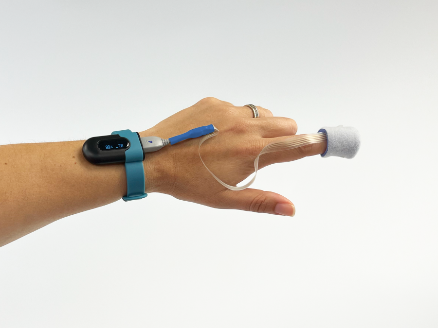 Functioning demo oximeter worn on a hand with electronics controller on the wrist and a fingertip bio sensor.