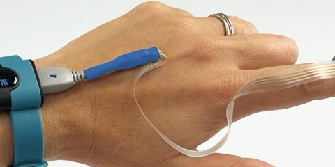 Functional printed silver circuit SpO2 sensor on TPU film with electronic components worn on a hand.