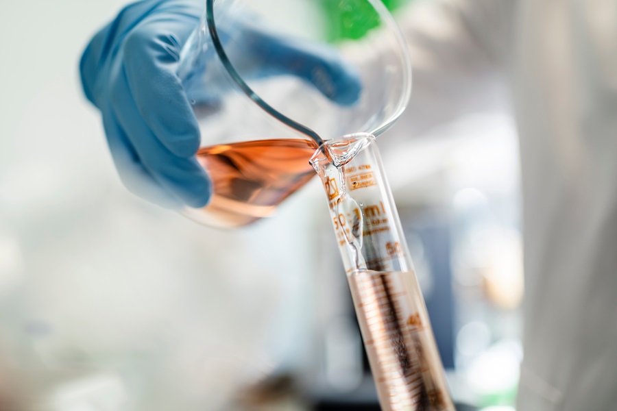 Scientist pouring a chemical liquid into a test tube