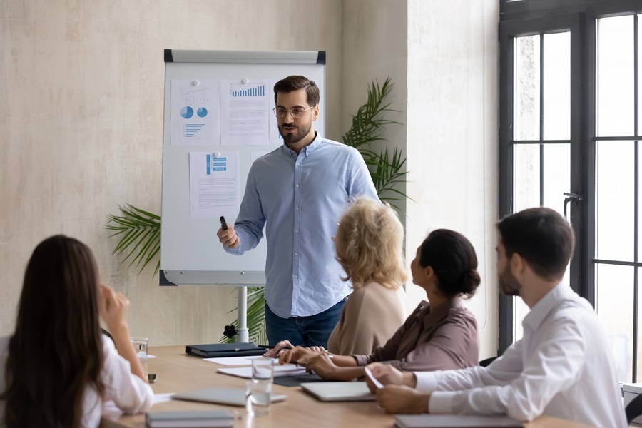Confident handsome businessman flip charts presentation new project in boardroom at company meeting